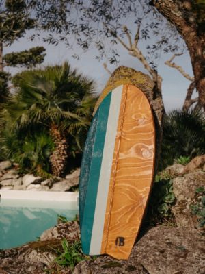 La planche d'équilibre Vert Bois modèle bois foncé en présentation devant la piscine