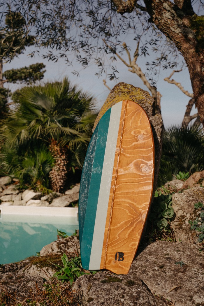 La planche d'équilibre Vert Bois modèle bois foncé en présentation devant la piscine