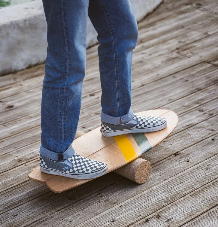 zoom sur les pieds d'un surfeur qui fait de la balance board